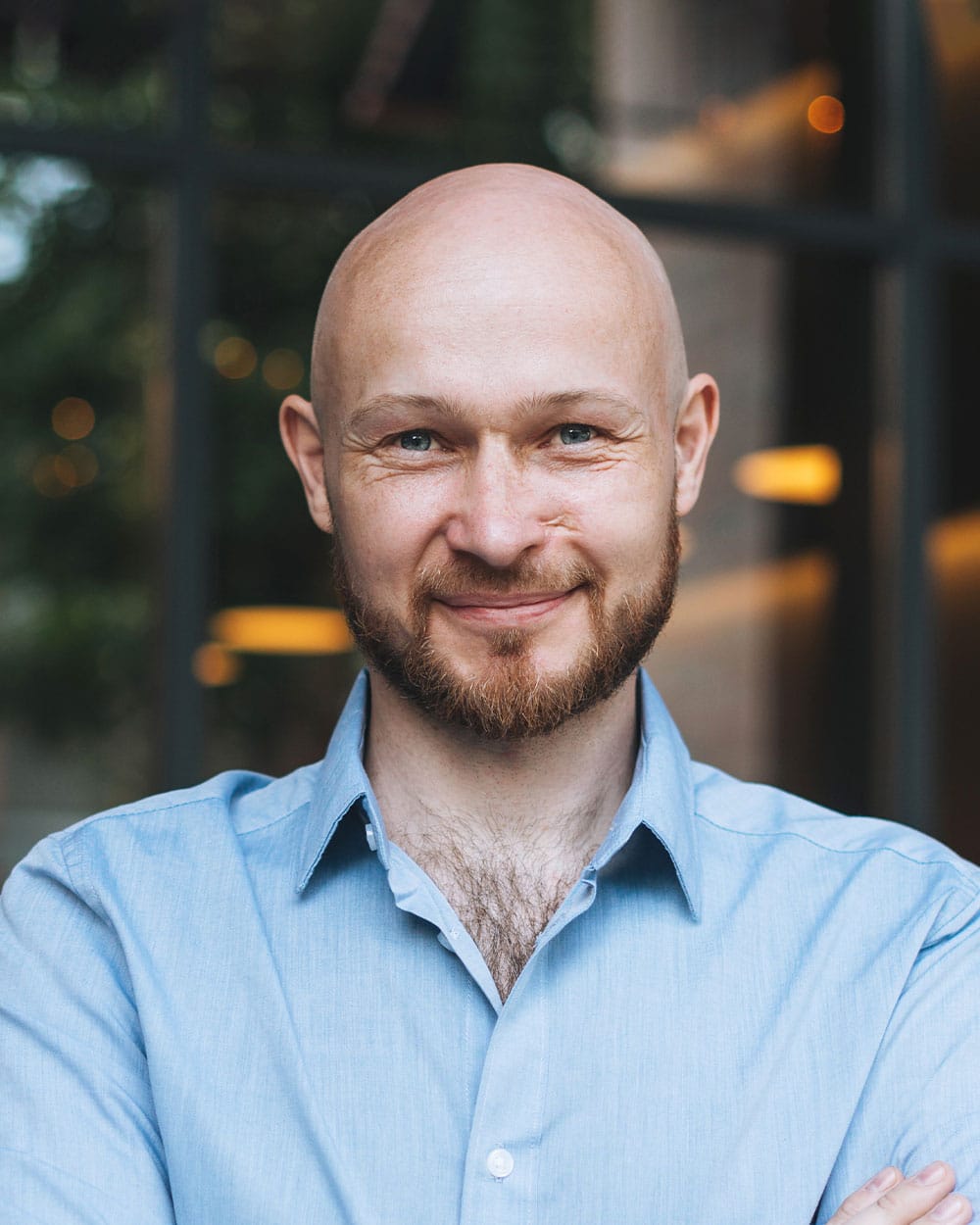 a man wearing glasses and smiling at the camera