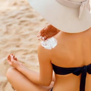 A woman applies sunscreen to her arm to protect her newly smooth skin.